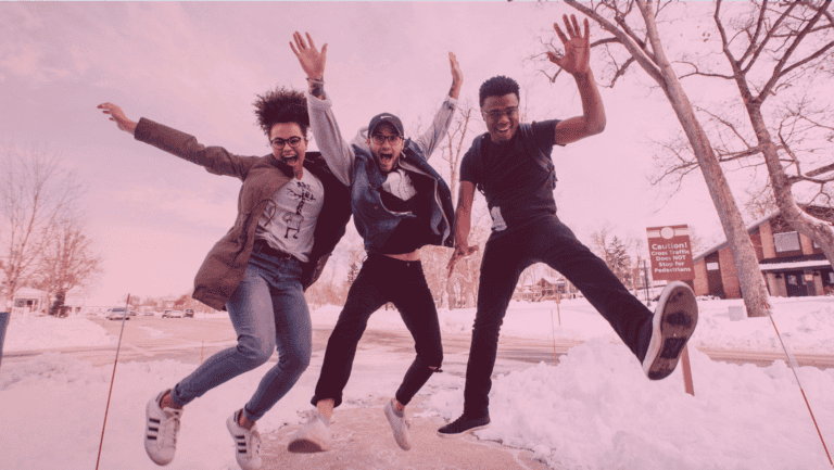 Grupo de pessoas pulando na neve durante intercâmbio internacional.