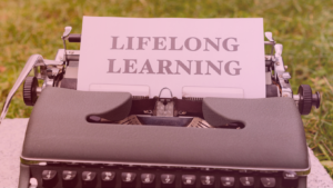 Máquina de escrever com a frase “Lifelong Learning” (Aprendizado ao longo da vida), representando o processo contínuo de aprender inglês na fase adulta e superar desafios como a transferência linguística.