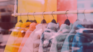 Vitrine com casacos estilosos, mostrando vocabulário de roupas em inglês como coat, jacket, parka e blazer, ideal para aprender a falar sobre moda com confiança.